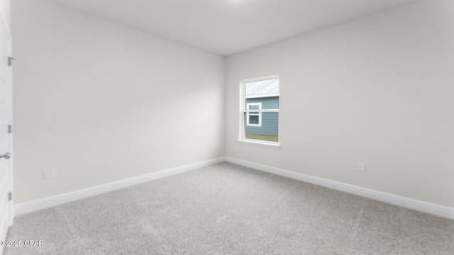 spare room featuring baseboards and carpet