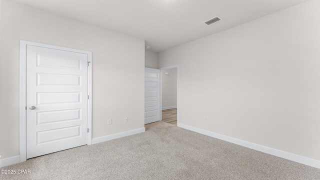 unfurnished bedroom featuring carpet floors, baseboards, and visible vents