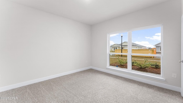 carpeted empty room with baseboards