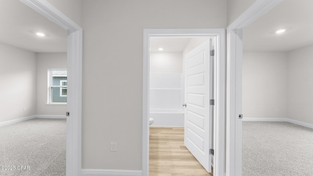 corridor with recessed lighting, baseboards, and light colored carpet