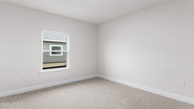 carpeted spare room featuring baseboards