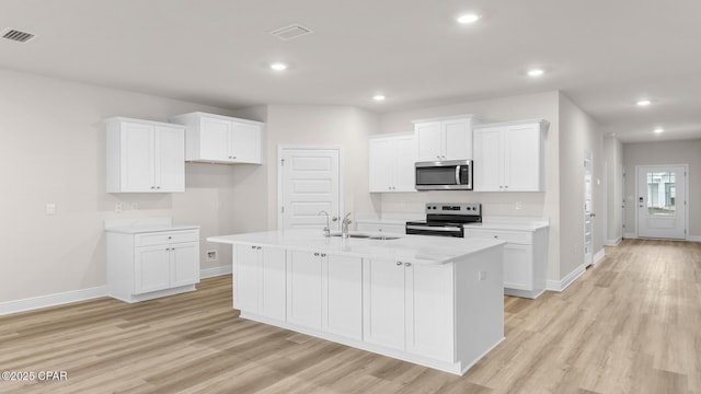 kitchen featuring a sink, appliances with stainless steel finishes, baseboards, and visible vents