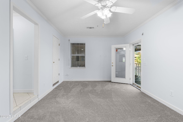 spare room featuring visible vents, ornamental molding, carpet floors, and a ceiling fan