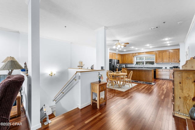 kitchen featuring a ceiling fan, visible vents, black fridge, and hardwood / wood-style floors