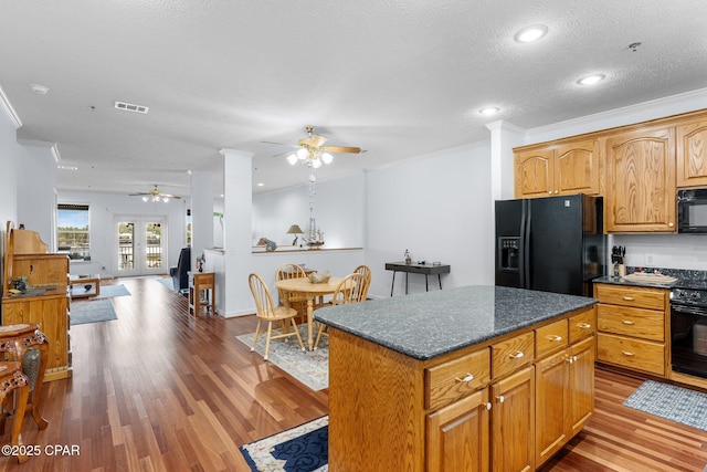 kitchen featuring a ceiling fan, wood finished floors, black appliances, and ornamental molding
