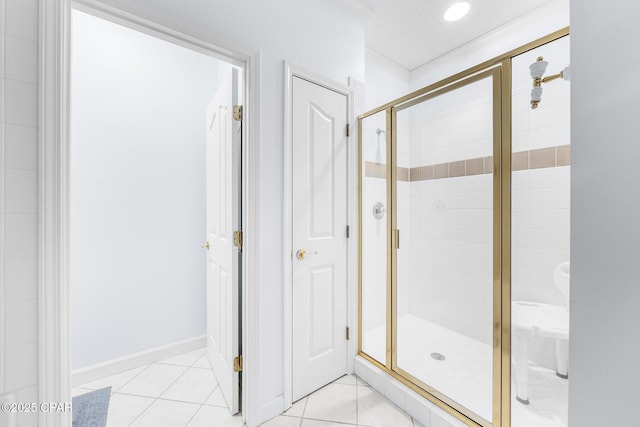 bathroom with tile patterned flooring, ornamental molding, and a shower stall
