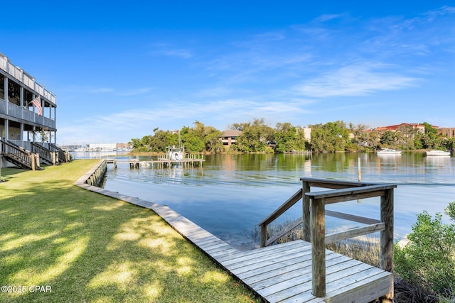 dock area with a yard and a water view