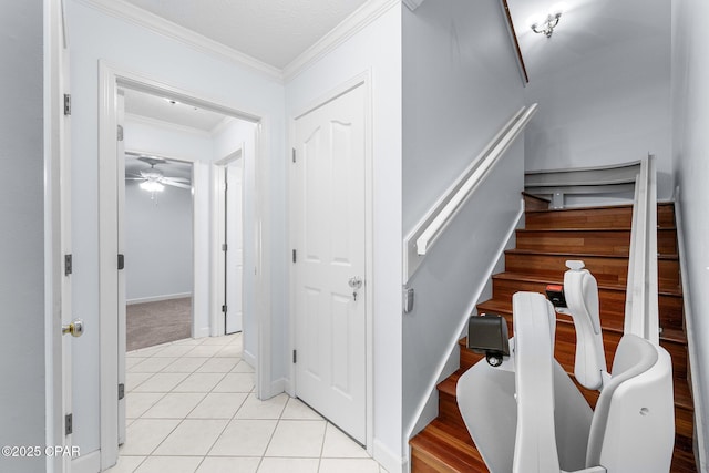 stairs featuring crown molding, a ceiling fan, baseboards, and tile patterned flooring