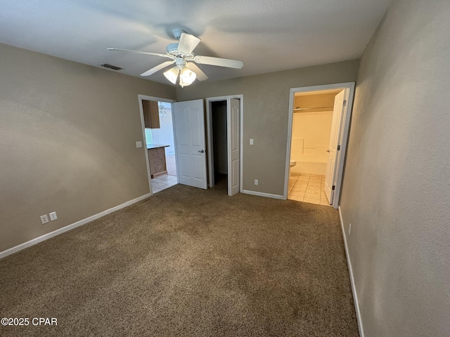 unfurnished bedroom with ensuite bathroom, ceiling fan, carpet, baseboards, and visible vents