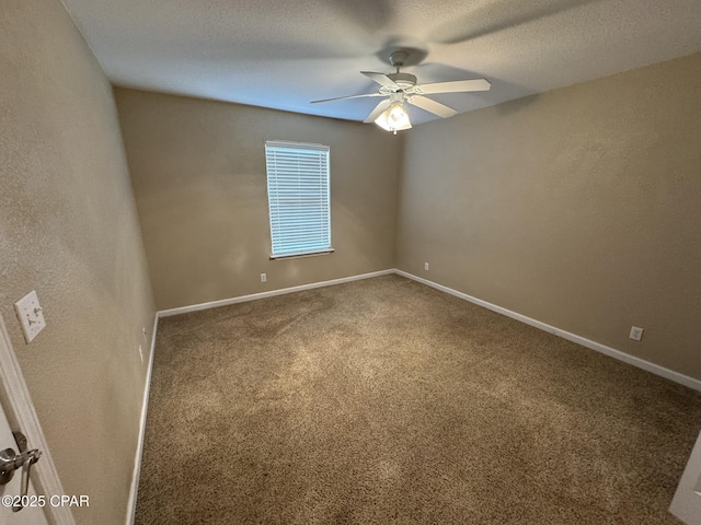 carpeted empty room featuring a ceiling fan and baseboards