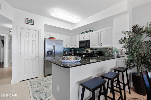 14825 Front Beach Rd Unit 2209, Panama City Beach, FL 32413 - kitchen featuring appliances with stainless steel finishes, a kitchen breakfast bar, a peninsula, backsplash, and light tile patterned floors