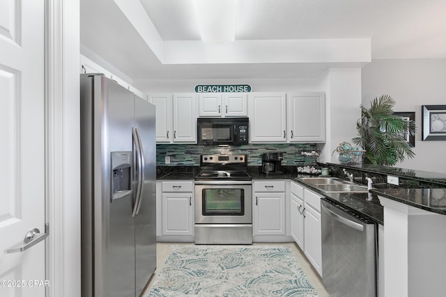 14825 Front Beach Rd Unit 2209, Panama City Beach, FL 32413 - kitchen featuring appliances with stainless steel finishes, a sink, white cabinets, tasteful backsplash, and a peninsula