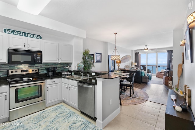 14825 Front Beach Rd Unit 2209, Panama City Beach, FL 32413 - kitchen featuring appliances with stainless steel finishes, a peninsula, dark countertops, backsplash, and open floor plan