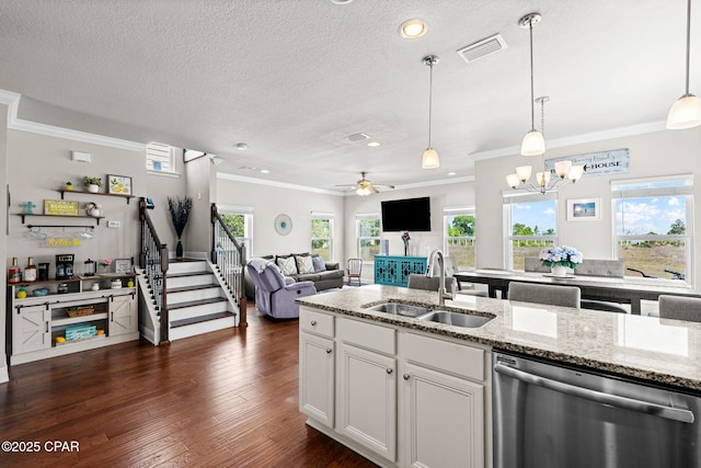 kitchen with a sink, ornamental molding, open floor plan, and dishwasher