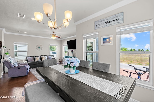 dining room with crown molding, visible vents, a healthy amount of sunlight, and wood finished floors