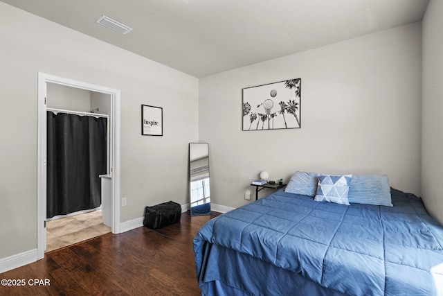 bedroom featuring visible vents, baseboards, and wood finished floors