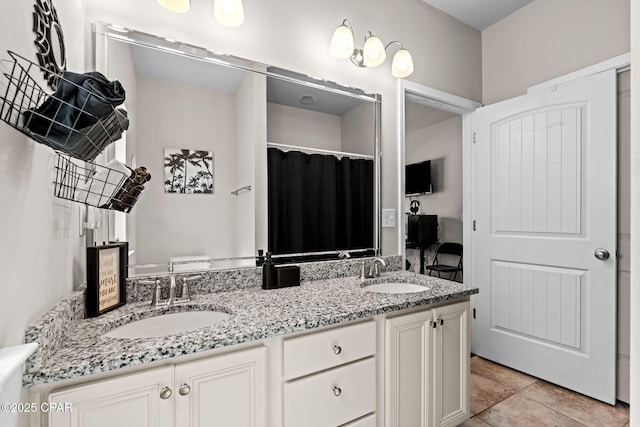 bathroom with double vanity, tile patterned floors, and a sink