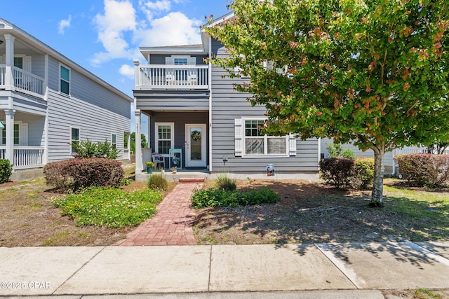 multi unit property with a porch and a balcony