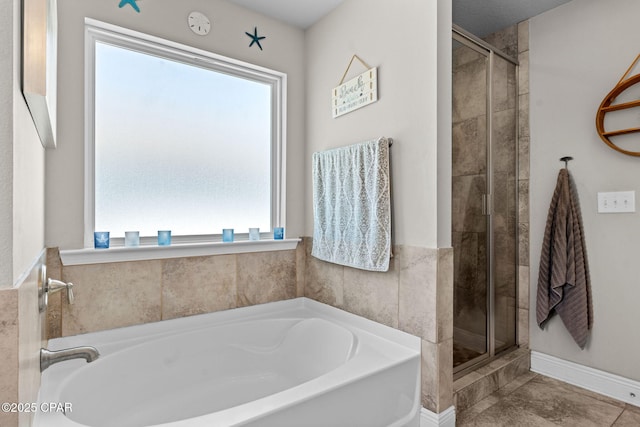 full bathroom featuring a garden tub, baseboards, and a shower stall