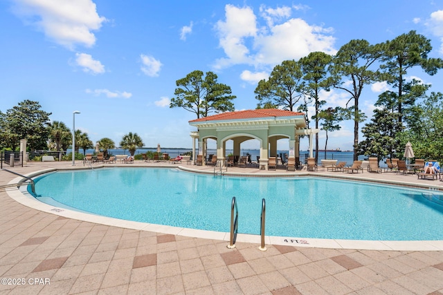 community pool with a patio and fence
