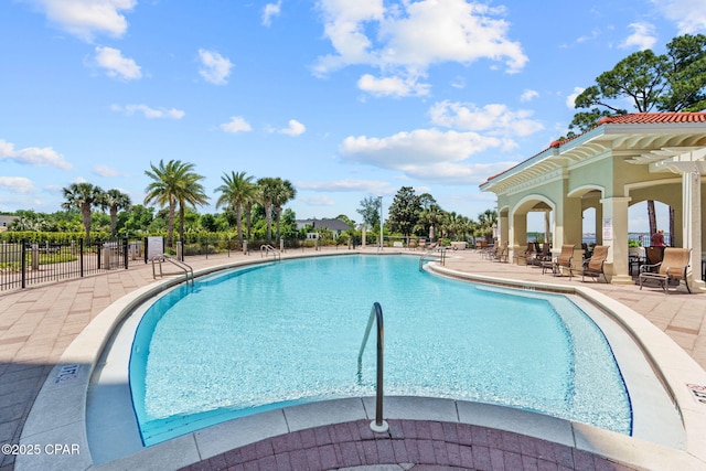 pool with a patio area and fence