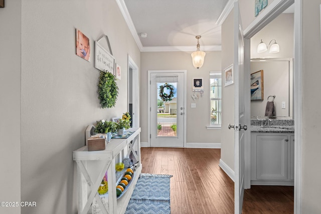foyer with baseboards, ornamental molding, and hardwood / wood-style floors