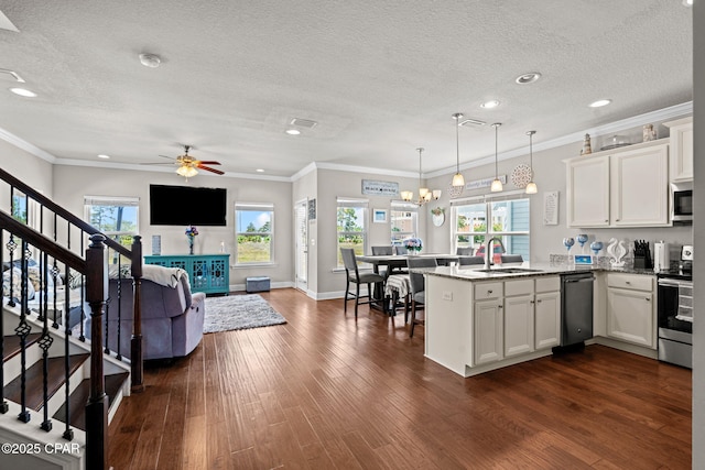 kitchen with a peninsula, a textured ceiling, appliances with stainless steel finishes, and a sink