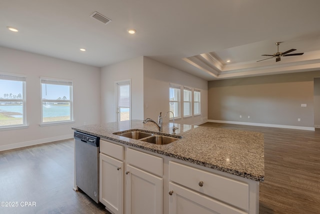 kitchen with open floor plan, dishwasher, dark wood-type flooring, and a sink