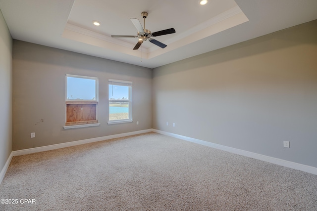 carpeted empty room with ornamental molding, recessed lighting, baseboards, and a tray ceiling