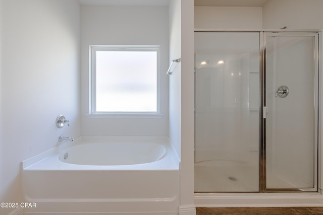 bathroom featuring a stall shower and a bath