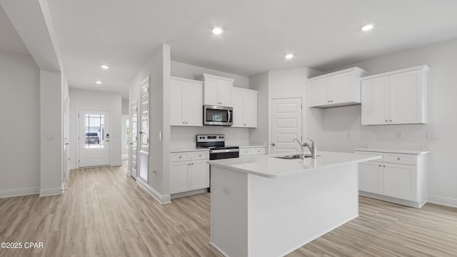 kitchen featuring light wood-style floors, appliances with stainless steel finishes, and a sink