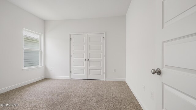 unfurnished bedroom with carpet flooring and baseboards