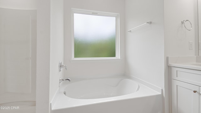 bathroom with a bath, plenty of natural light, and vanity