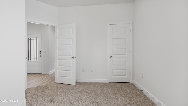 carpeted empty room with baseboards