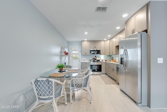 kitchen featuring recessed lighting, stainless steel appliances, light countertops, visible vents, and gray cabinets