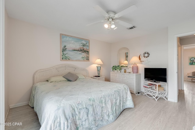 bedroom featuring ceiling fan, baseboards, visible vents, and light wood-style flooring