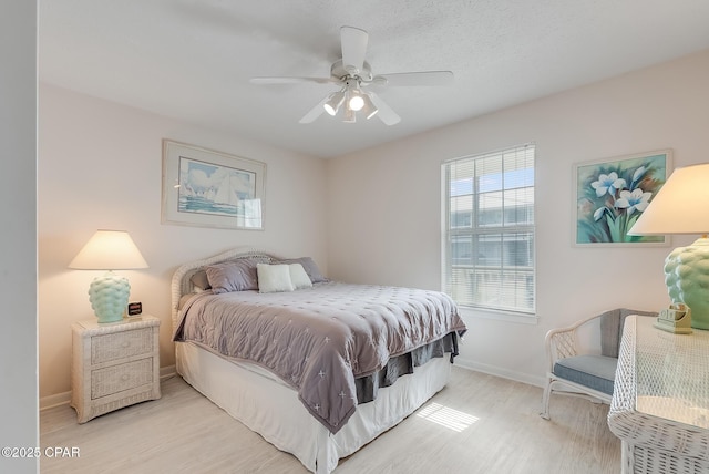 bedroom with baseboards, a ceiling fan, and wood finished floors