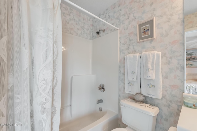 bathroom featuring wallpapered walls, shower / bath combo with shower curtain, and toilet