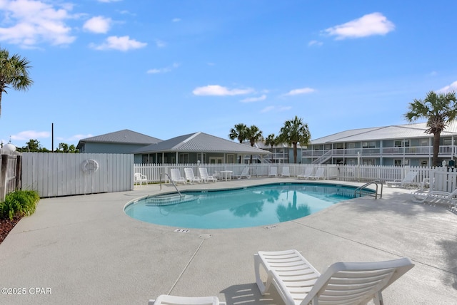 community pool with fence and a patio area