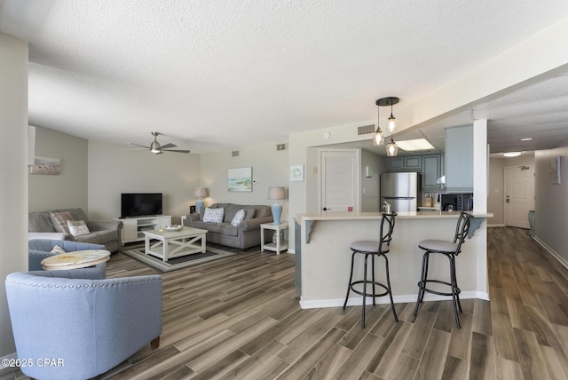 17155 Front Beach Rd Unit E602, Panama City Beach, FL 32413 - living room with dark wood-type flooring, a ceiling fan, a textured ceiling, and baseboards
