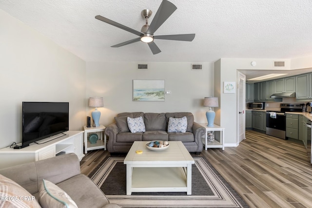 17155 Front Beach Rd Unit E602, Panama City Beach, FL 32413 - living room featuring wood finished floors, a ceiling fan, a textured ceiling, and baseboards