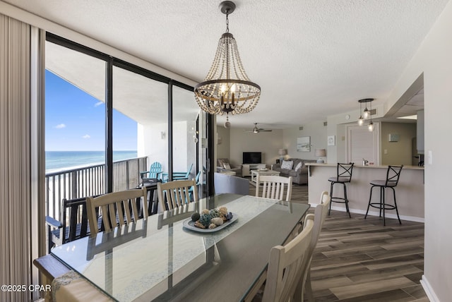17155 Front Beach Rd Unit E602, Panama City Beach, FL 32413 - dining area with a water view, a textured ceiling, a chandelier, wood finished floors, and baseboards