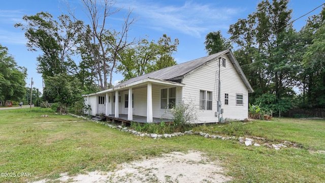 view of property exterior with a porch and a yard