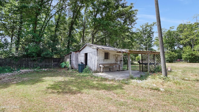 view of outbuilding with an outdoor structure, fence, and a carport