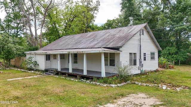 view of front of house with a porch, a front lawn, and fence