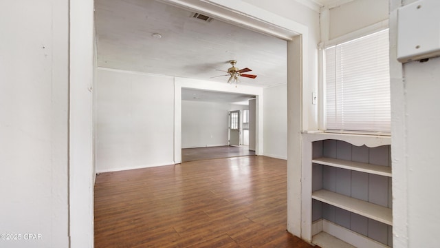 corridor featuring baseboards, wood finished floors, and visible vents