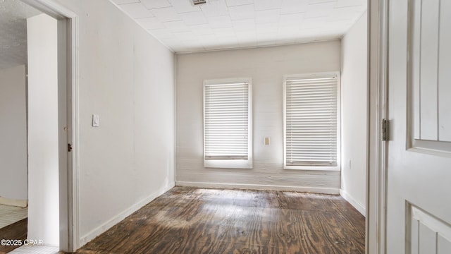 spare room featuring wood finished floors and baseboards