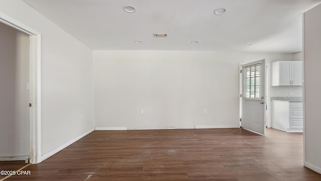 unfurnished living room featuring visible vents, baseboards, recessed lighting, and dark wood-style flooring