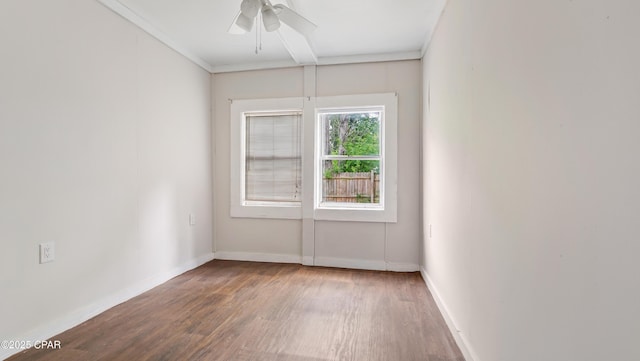 unfurnished room with ornamental molding, baseboards, wood finished floors, and ceiling fan