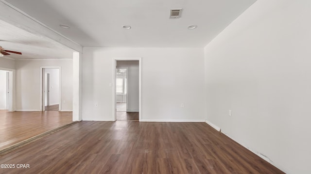unfurnished room with ceiling fan, baseboards, wood finished floors, and visible vents
